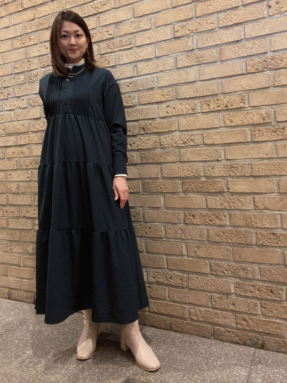 ブルー系のワンピース、ホワイト系のTシャツ/カットソー、ホワイト系のブーツを着用したレディースの春コーディネートの1枚目の写真