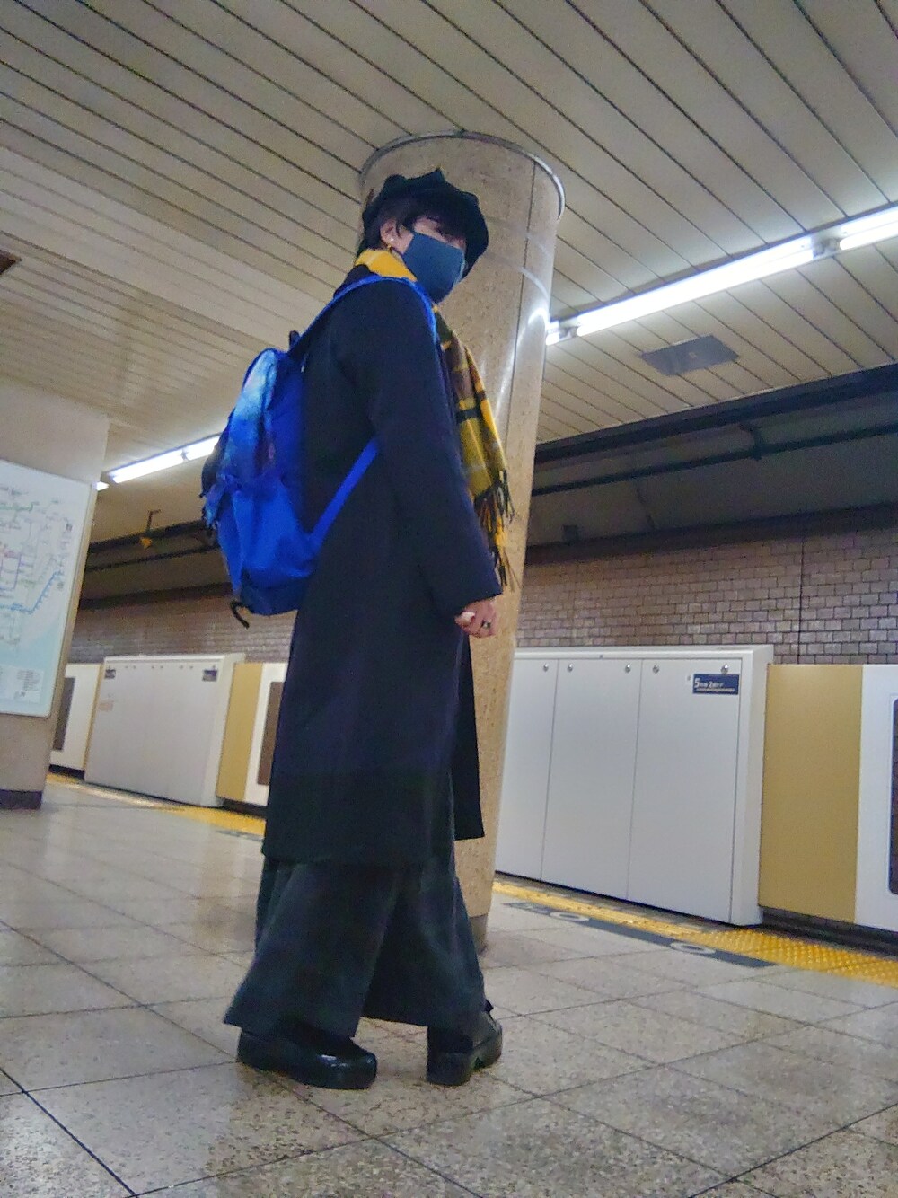 ブラック系のスニーカー、グレー系のその他パンツ、ブラック系のステンカラーコートを着用したメンズの冬コーディネートの2枚目の写真