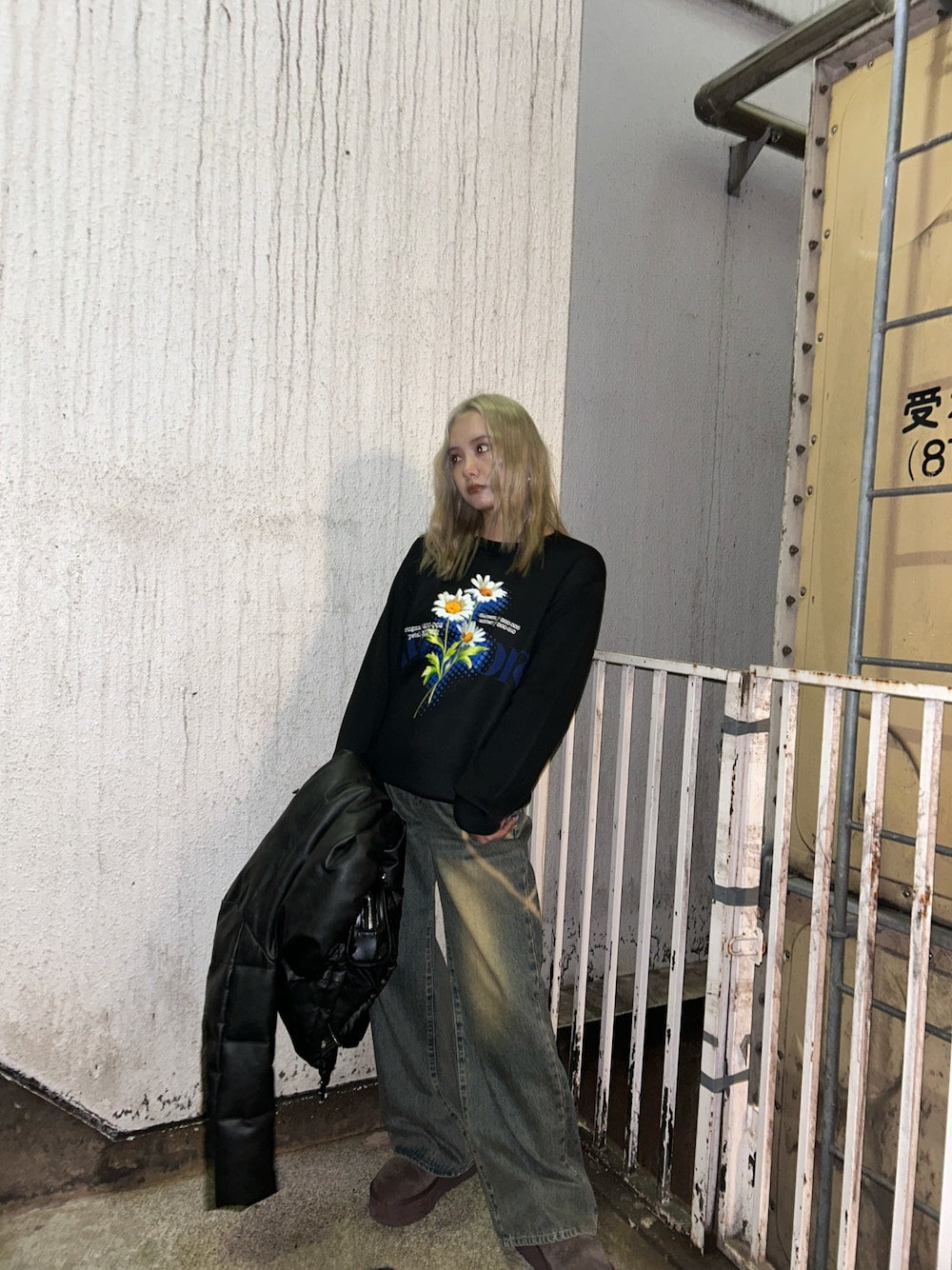 ブラック系のニット/セーター、ブルー系のデニムパンツを着用したレディースの冬コーディネートの1枚目の写真