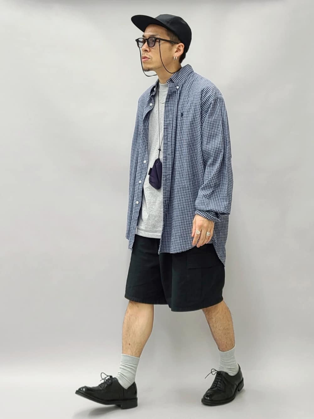 ブラック系のドレスシューズ、パープル系のショルダーバッグ、ブラック系のキャップを着用したメンズの秋コーディネートの1枚目の写真