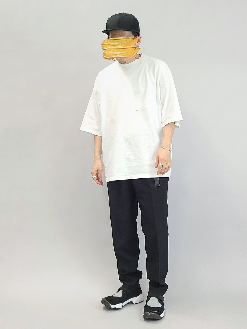 ブラック系のスラックス、ブラック系のスニーカー、ホワイト系のTシャツ/カットソーを着用したメンズの夏コーディネートの1枚目の写真