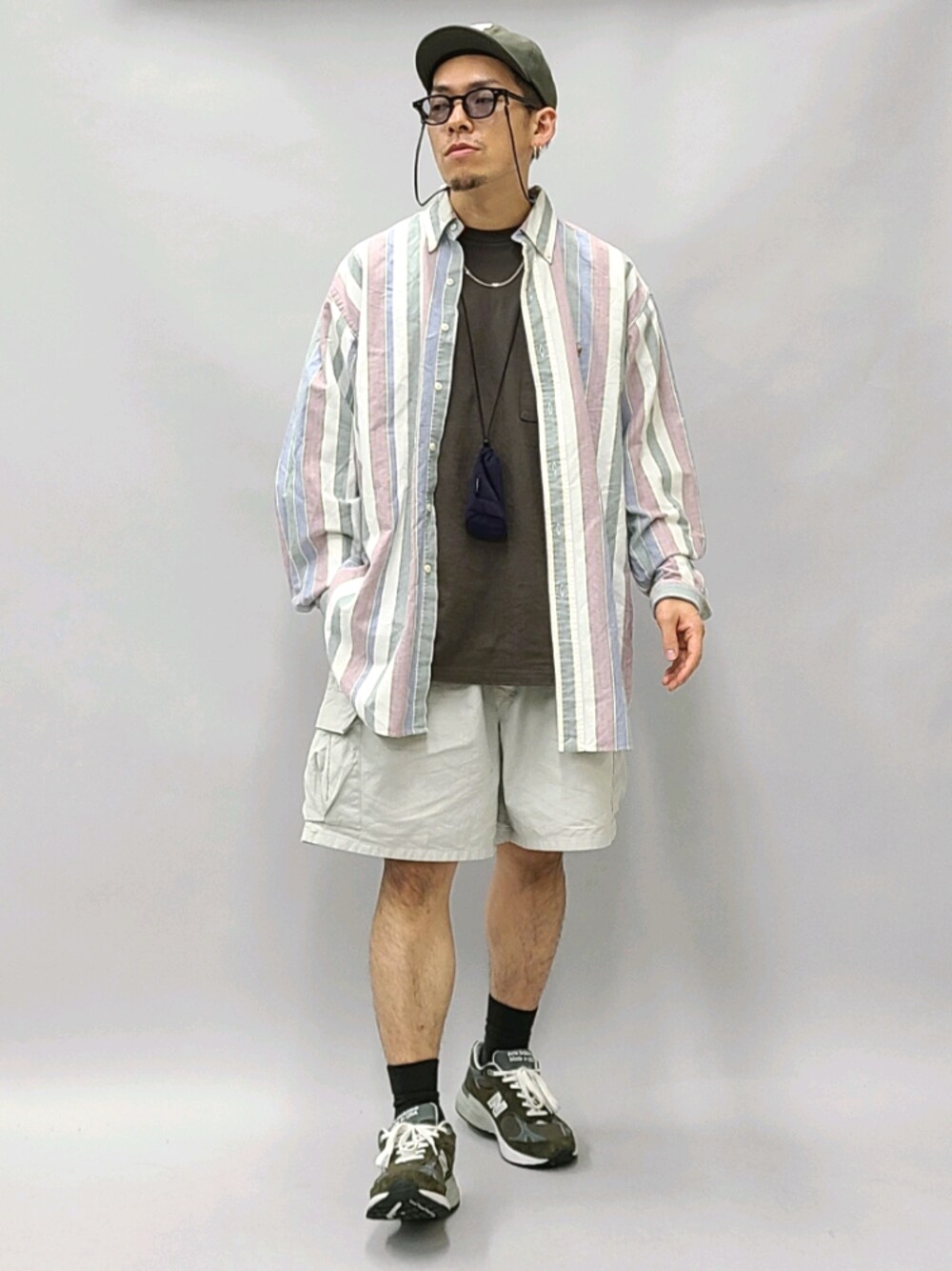 ブラウン系のTシャツ/カットソー、パープル系のショルダーバッグ、グリーン系のスニーカーを着用したメンズの秋コーディネートの1枚目の写真