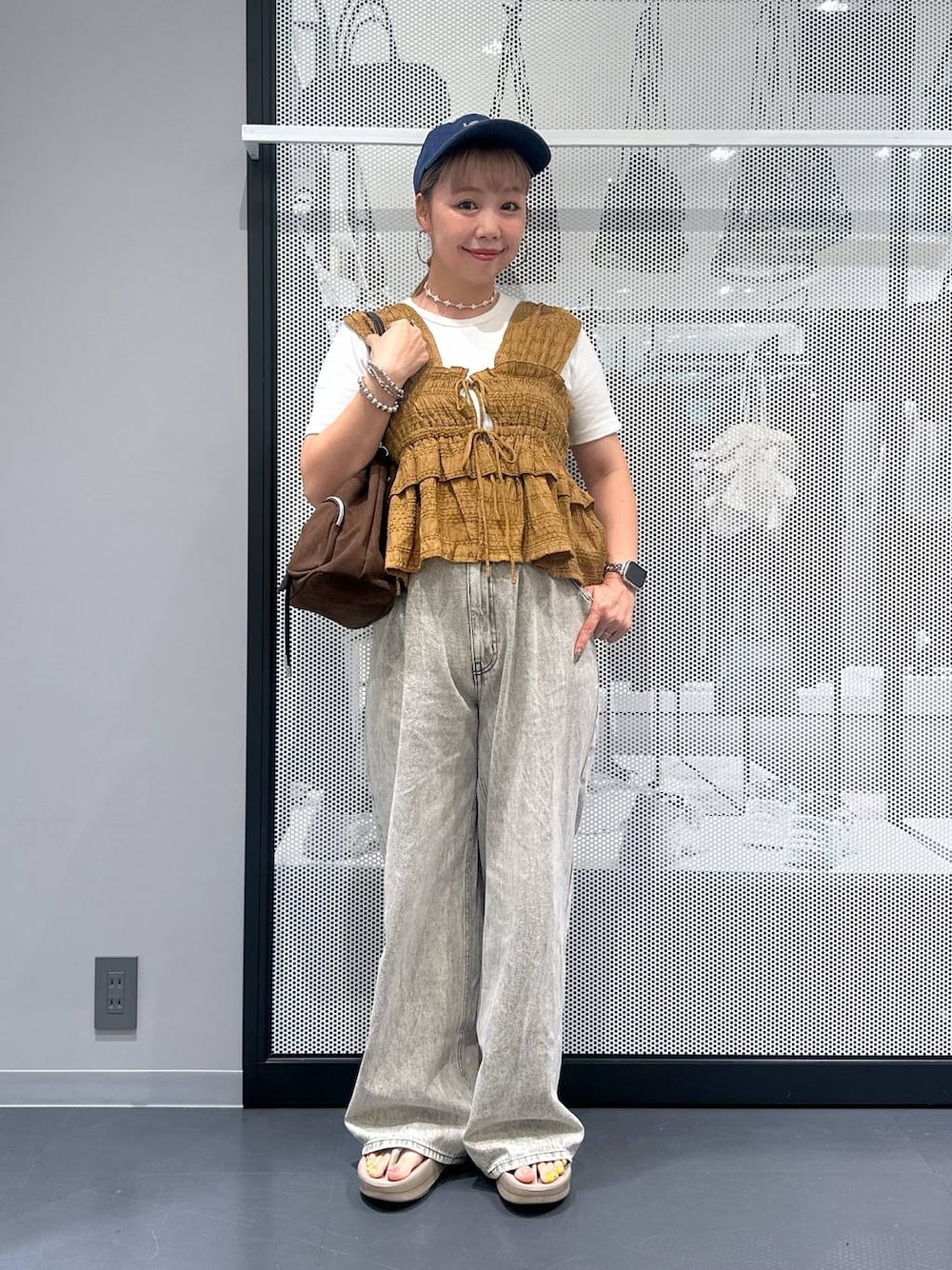 グレー系のデニムパンツ、ホワイト系のTシャツ/カットソー、ベージュ系のサンダルを着用したレディースの夏コーディネートの1枚目の写真