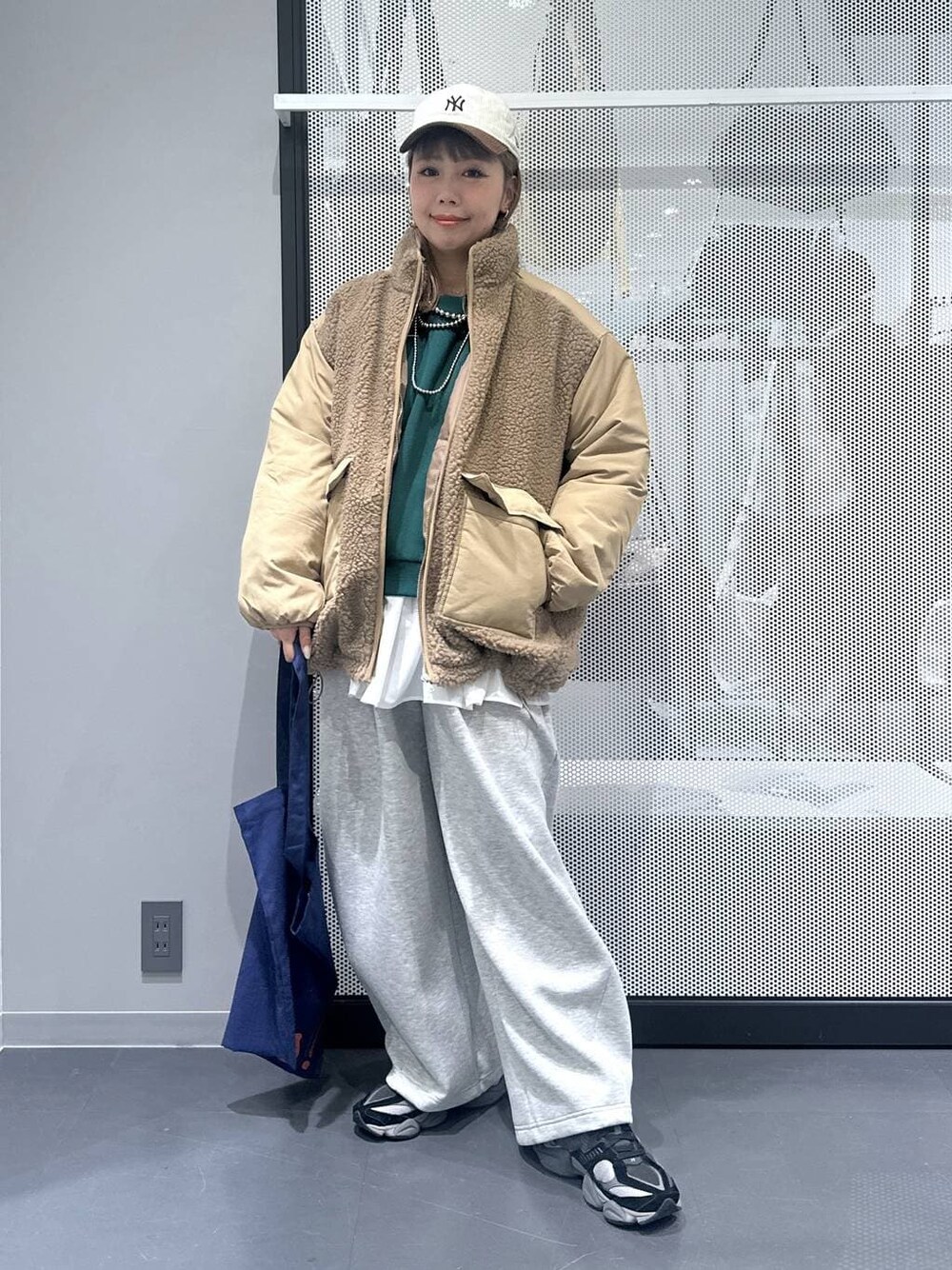 ブルー系のトートバッグ、ベージュ系のブルゾン、ブラック系のショルダーバッグを着用したレディースの冬コーディネートの1枚目の写真