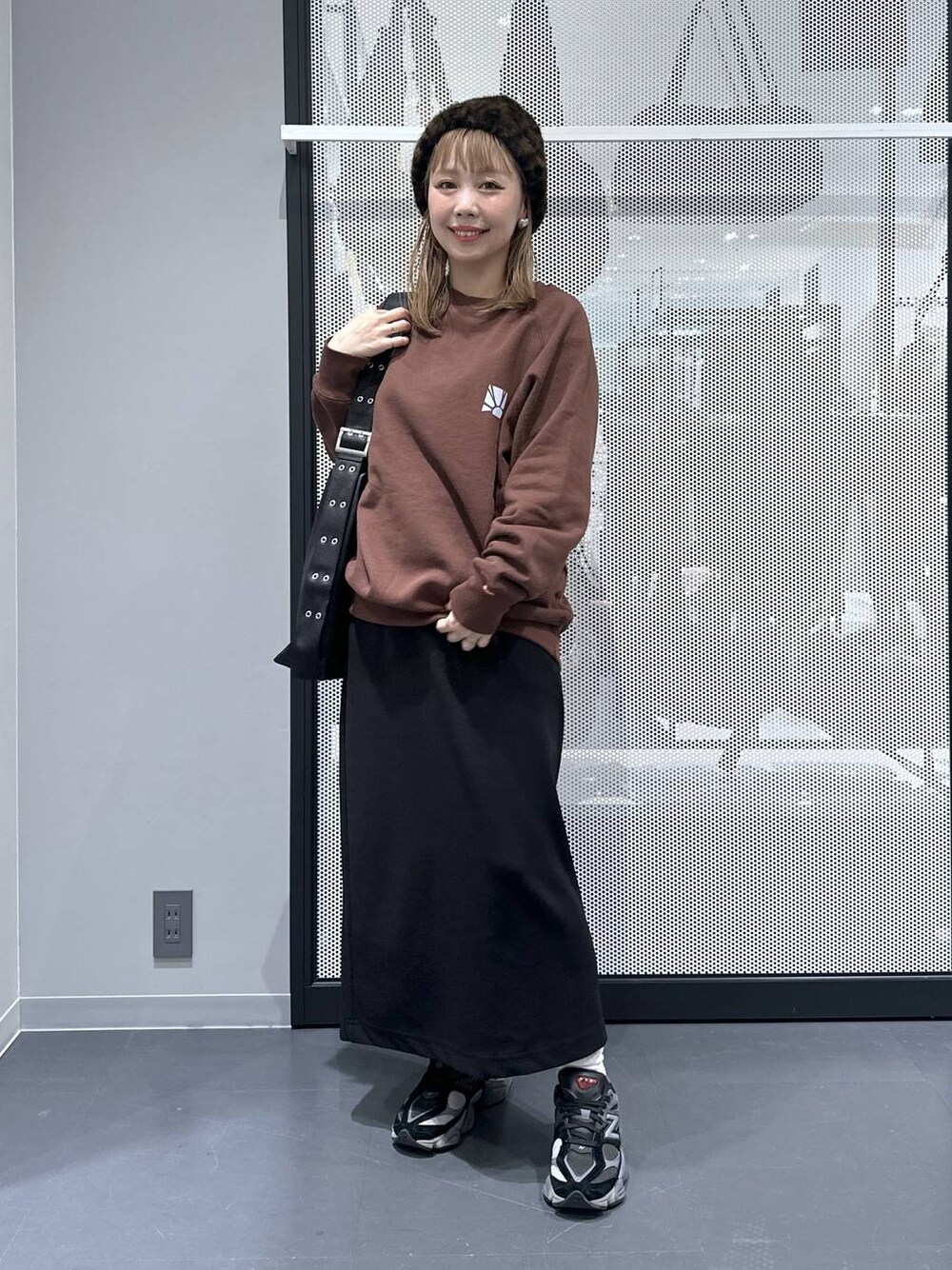 ブラック系のスカート、ブラック系のショルダーバッグ、その他のピアス(両耳用)を着用したレディースの冬コーディネートの1枚目の写真