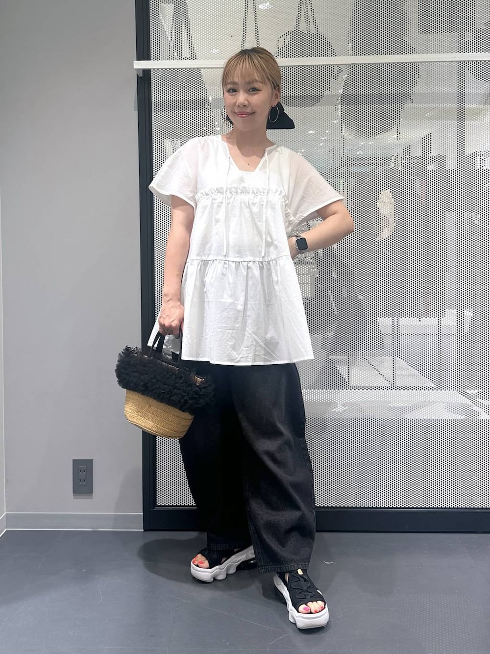 ブラック系のデニムパンツ、ベージュ系のショルダーバッグ、ホワイト系のタンクトップを着用したレディースの夏コーディネートの1枚目の写真