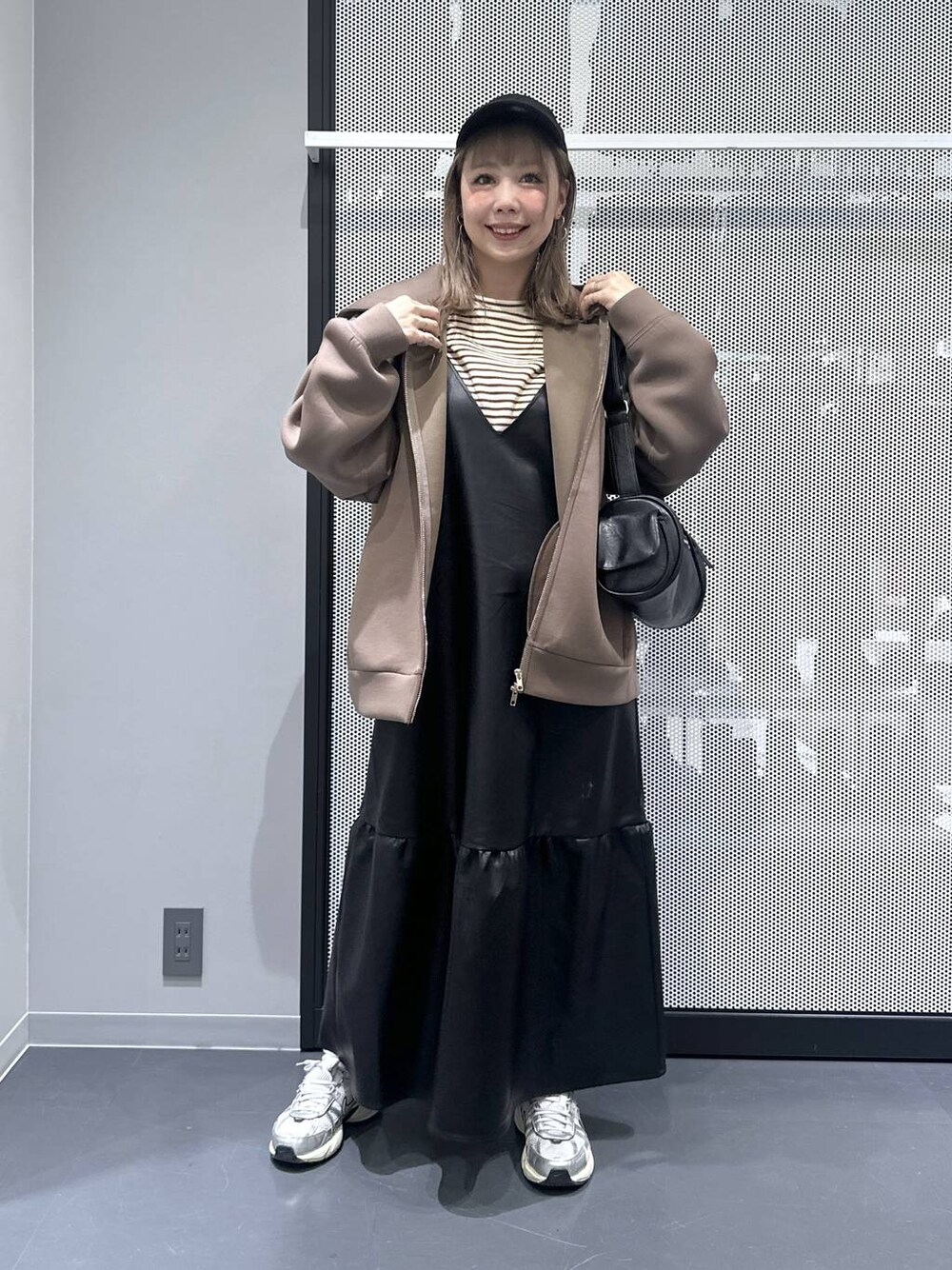 ブラウン系のパーカー、その他のピアス(両耳用)、ブルー系のキャップを着用したレディースの秋コーディネートの1枚目の写真