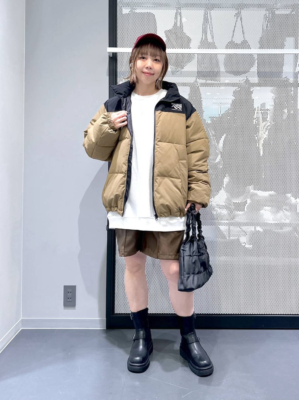 ベージュ系のブルゾン、ブラック系のブーツ、ホワイト系のスウェットを着用したレディースの冬コーディネートの1枚目の写真