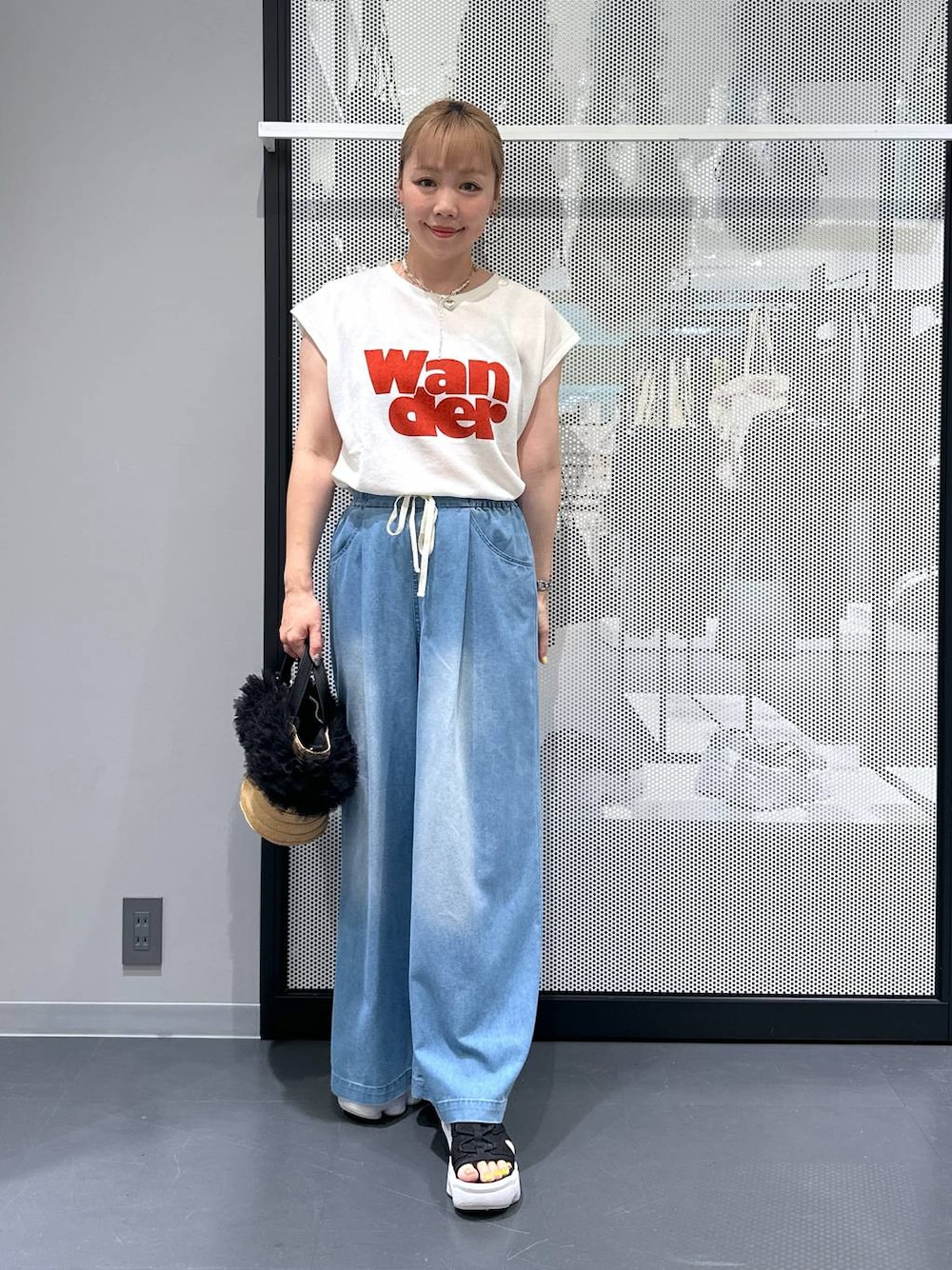 ベージュ系のショルダーバッグ、ブルー系のデニムパンツ、ホワイト系のTシャツ/カットソーを着用したレディースの夏コーディネートの1枚目の写真