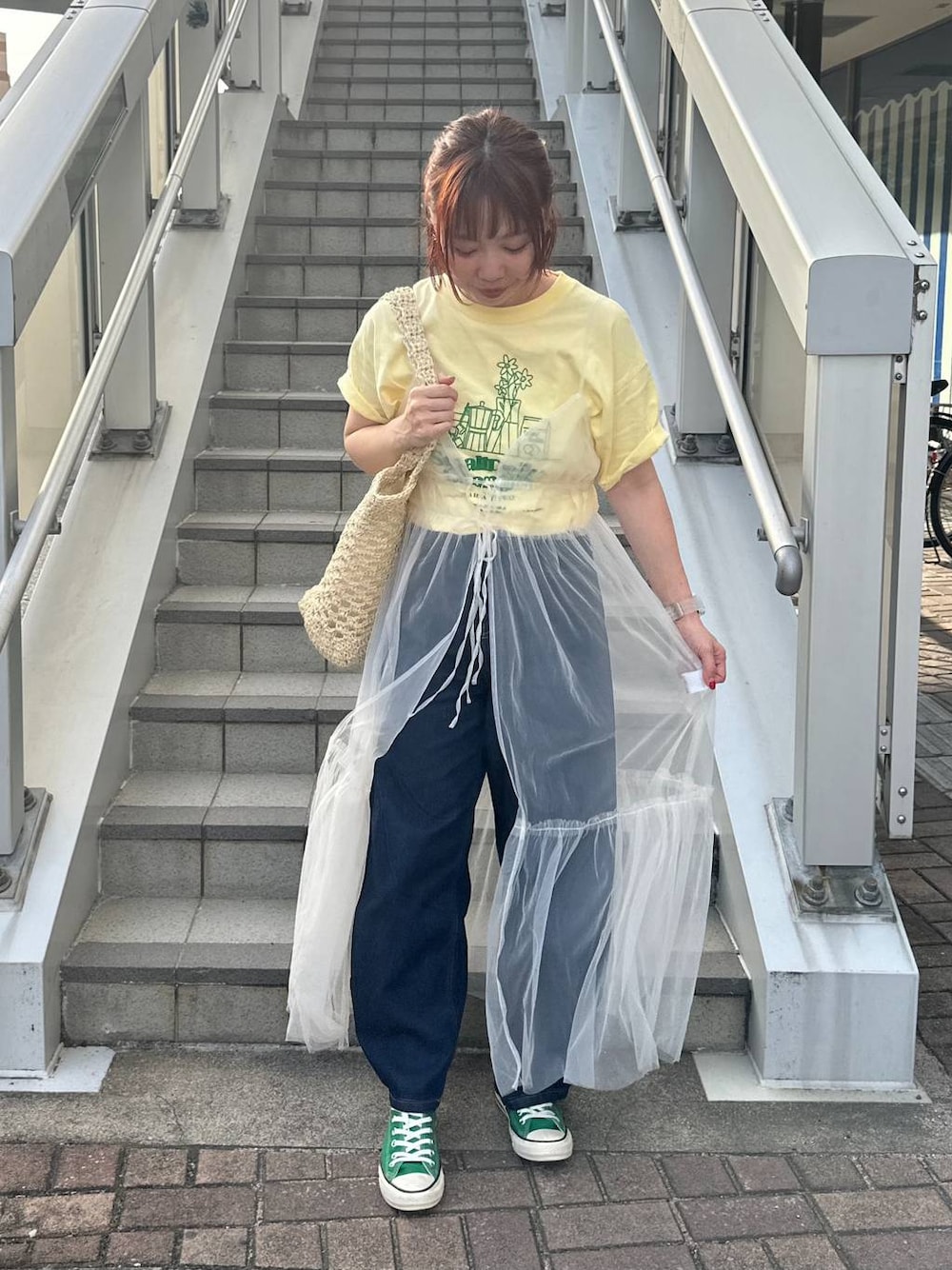 グリーン系のスニーカー、ホワイト系のトートバッグ、ベージュ系のTシャツ/カットソーを着用したレディースの春コーディネートの1枚目の写真
