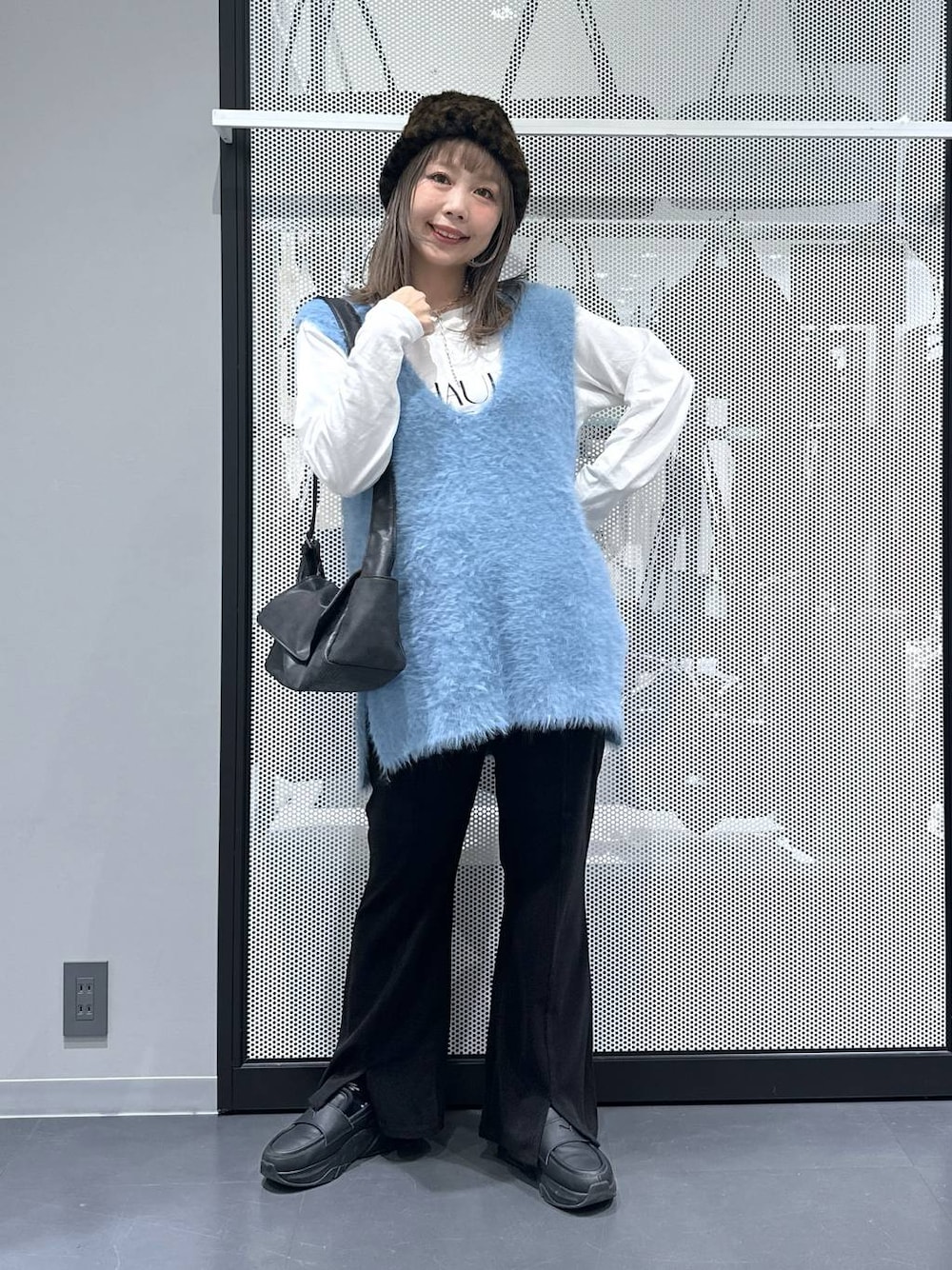 ブラック系のショルダーバッグ、ブルー系のベスト、ホワイト系のTシャツ/カットソーを着用したレディースの秋コーディネートの1枚目の写真