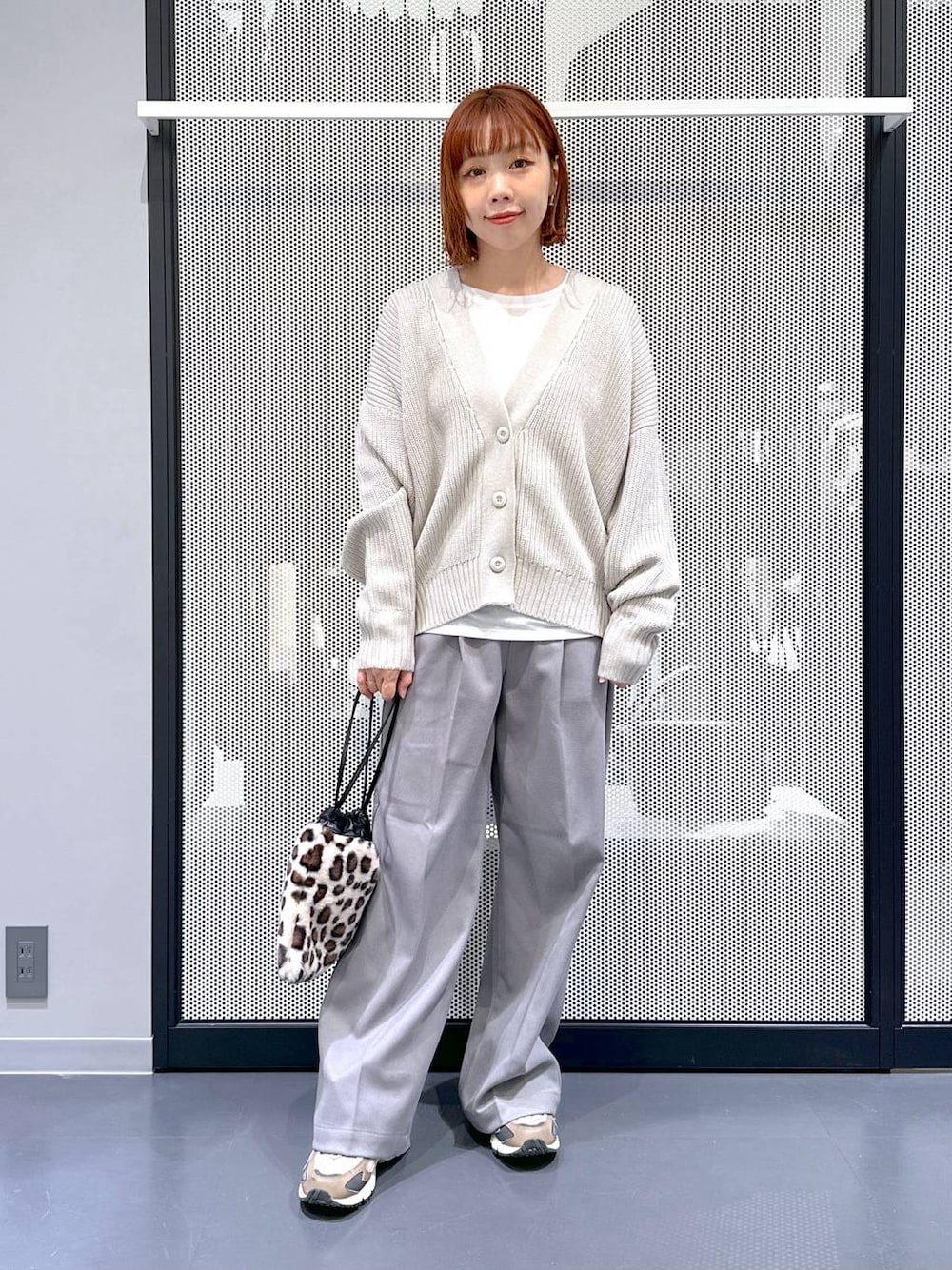 ブラウン系のスニーカー、グレー系のカーディガン/ボレロ、その他のショルダーバッグを着用したレディースの冬コーディネートの1枚目の写真