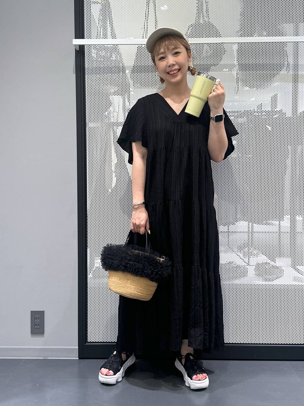 ベージュ系のショルダーバッグ、ブラック系のワンピース、ブラック系のサンダルを着用したレディースの春コーディネートの1枚目の写真