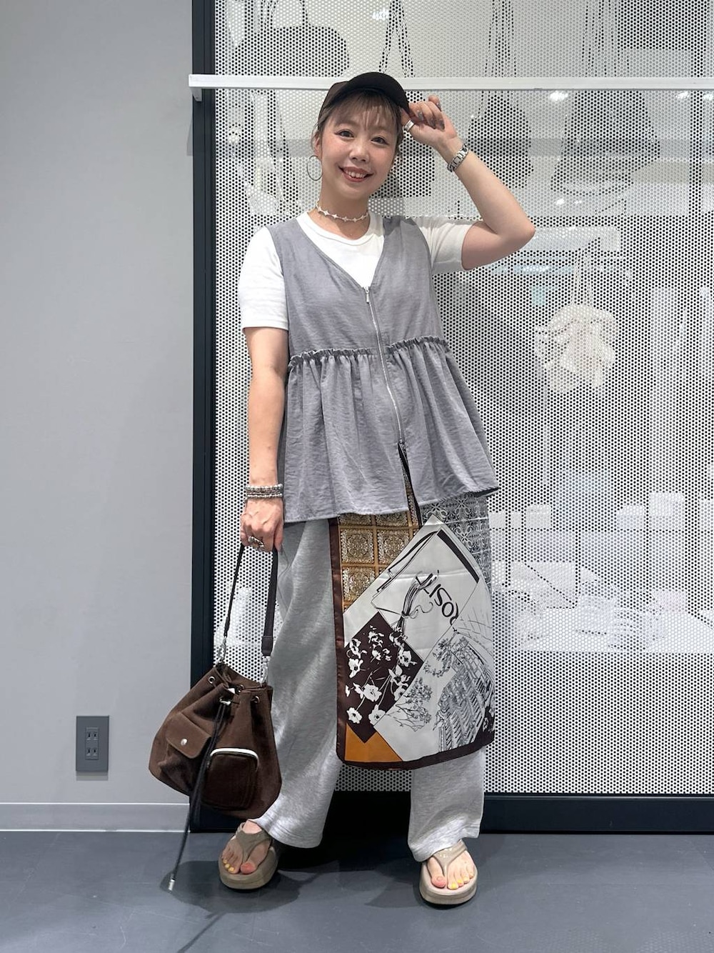 ホワイト系のTシャツ/カットソー、ブラウン系のショルダーバッグ、ベージュ系のサンダルを着用したレディースの夏コーディネートの1枚目の写真