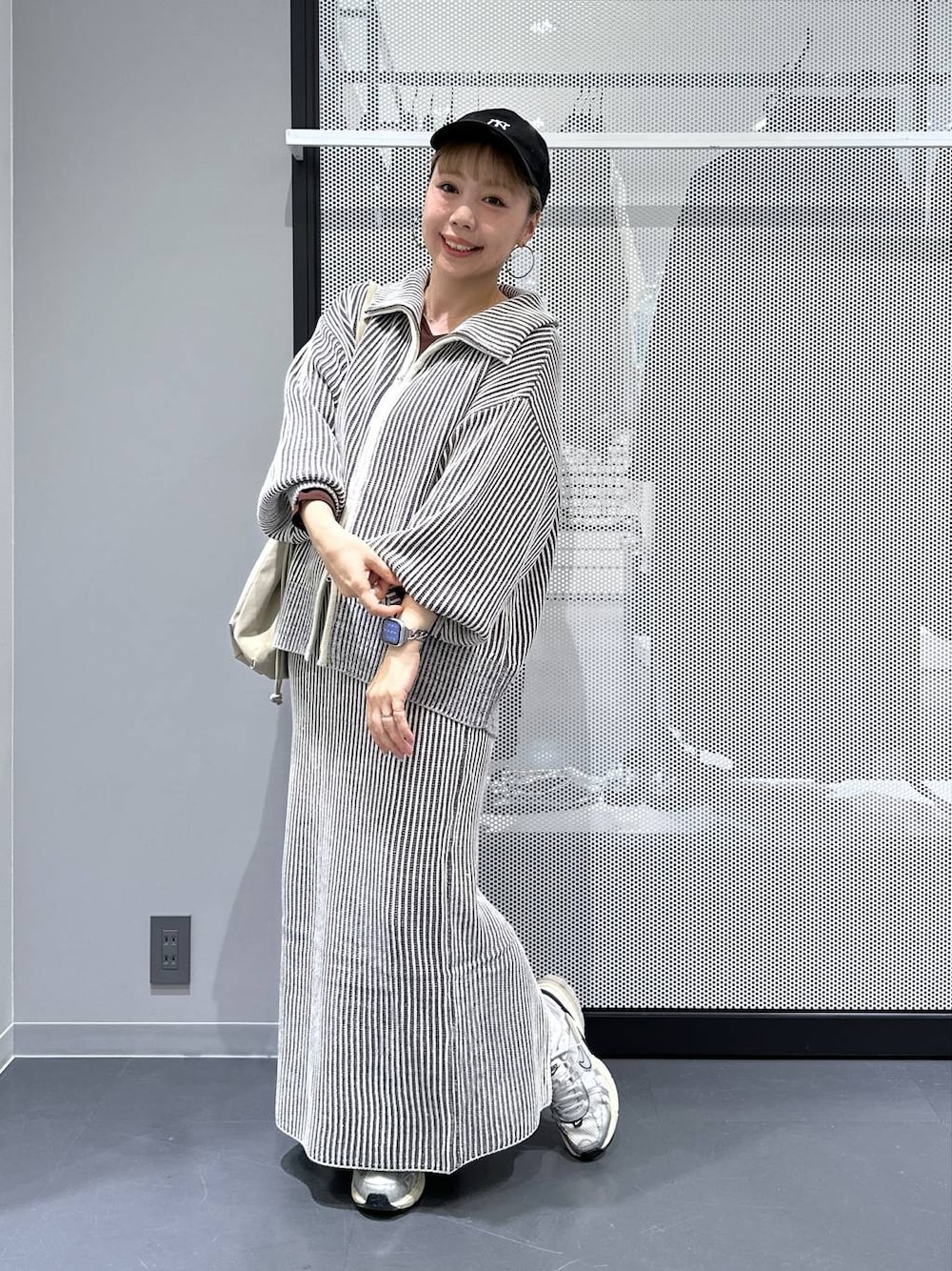 ベージュ系のトートバッグ、ベージュ系のスカート、ベージュ系のニット/セーターを着用したレディースの秋コーディネートの1枚目の写真