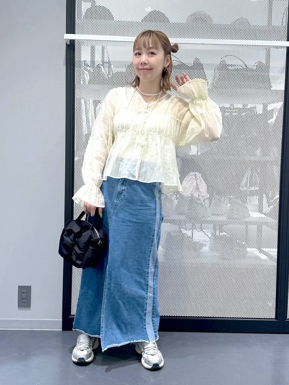 ブルー系のデニムスカート、ベージュ系のシャツ/ブラウス、ブラック系のショルダーバッグを着用したレディースの春コーディネートの1枚目の写真