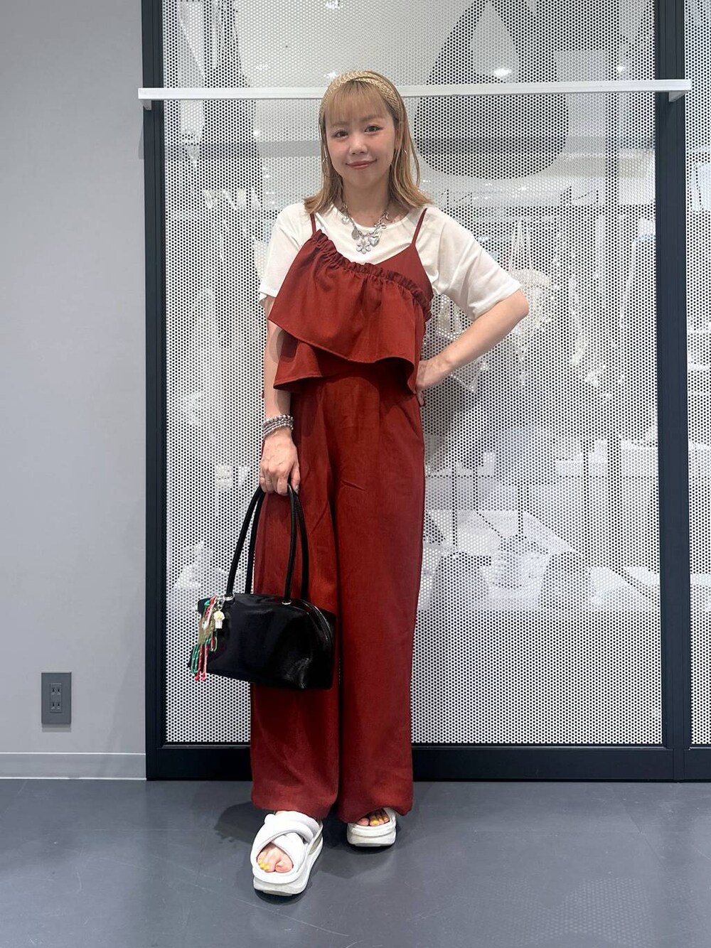 ブラック系のボストンバッグ、ホワイト系のTシャツ/カットソー、レッド系のつなぎ/オールインワンを着用したレディースの夏コーディネートの1枚目の写真