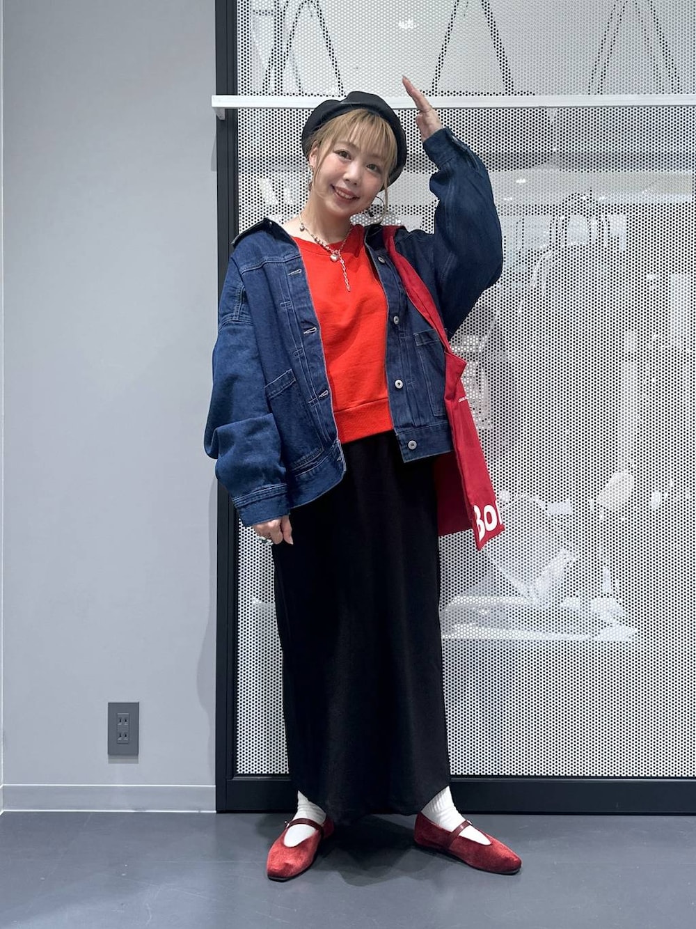 ブラック系のスカート、レッド系のトートバッグ、レッド系のパンプスを着用したレディースの秋コーディネートの1枚目の写真