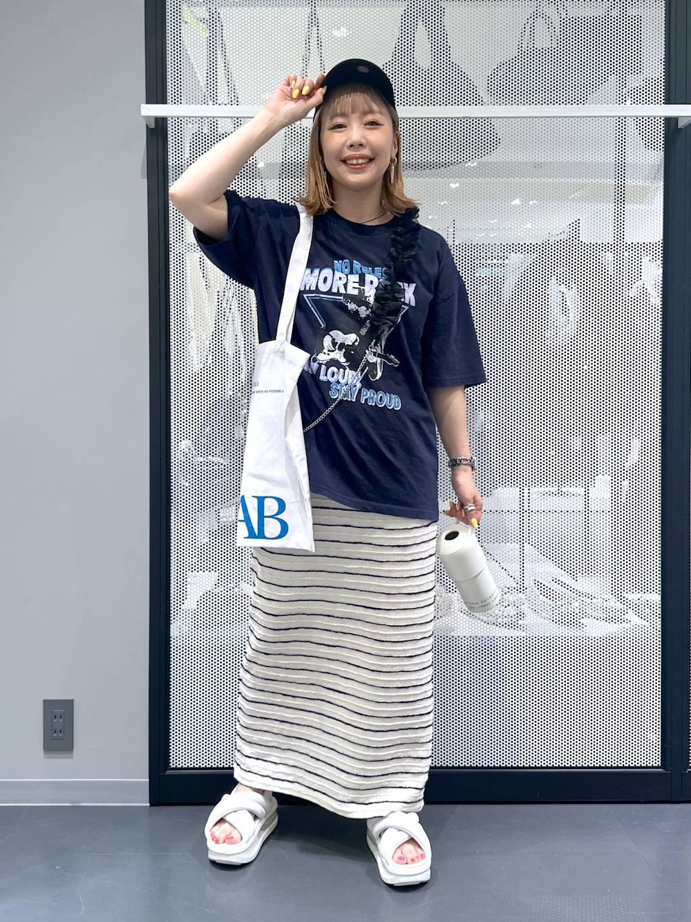 ホワイト系のトートバッグ、ホワイト系のスカート、ブルー系のTシャツ/カットソーを着用したレディースの春コーディネートの1枚目の写真
