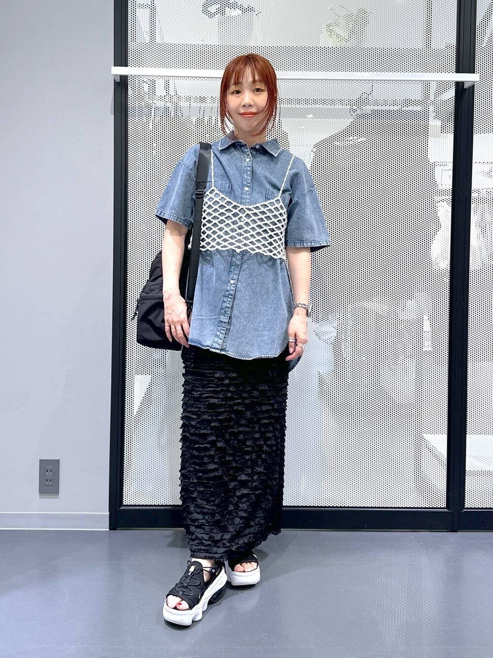 ブラック系のショルダーバッグ、ホワイト系のベスト、ブルー系のシャツ/ブラウスを着用したレディースの夏コーディネートの1枚目の写真