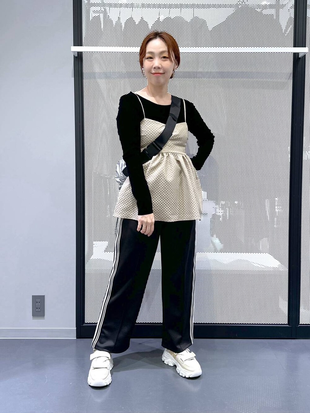 ベージュ系のスニーカー、ブラック系のその他パンツ、ブラック系のTシャツ/カットソーを着用したレディースの冬コーディネートの1枚目の写真