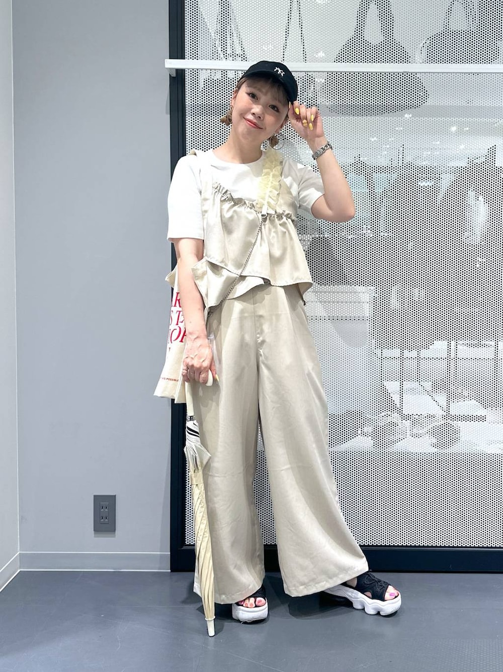 ホワイト系のトートバッグ、ホワイト系のTシャツ/カットソー、ベージュ系のつなぎ/オールインワンを着用したレディースの春コーディネートの1枚目の写真