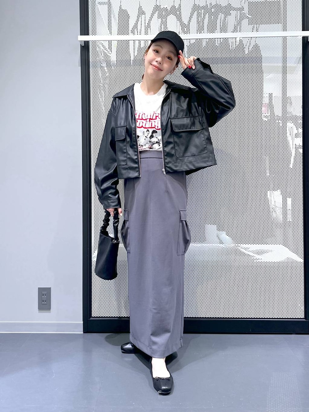 ブラック系のショルダーバッグ、ブラック系のブルゾン、ホワイト系のTシャツ/カットソーを着用したレディースの春コーディネートの1枚目の写真