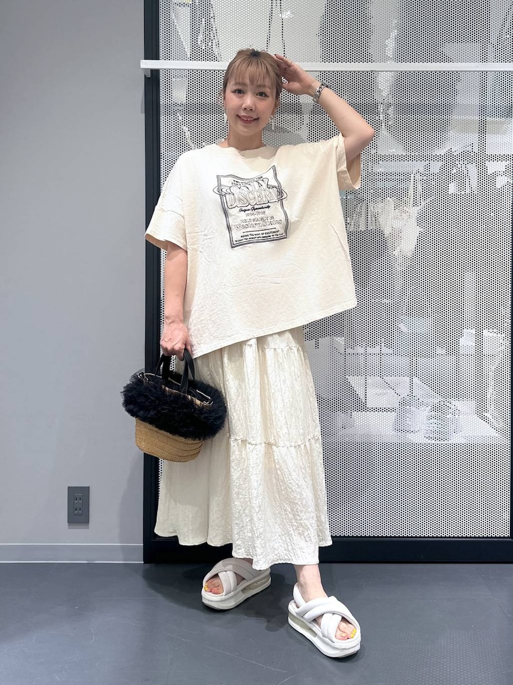 ベージュ系のショルダーバッグ、ホワイト系のスカート、ブラック系のバレッタ/ヘアクリップを着用したレディースの夏コーディネートの1枚目の写真