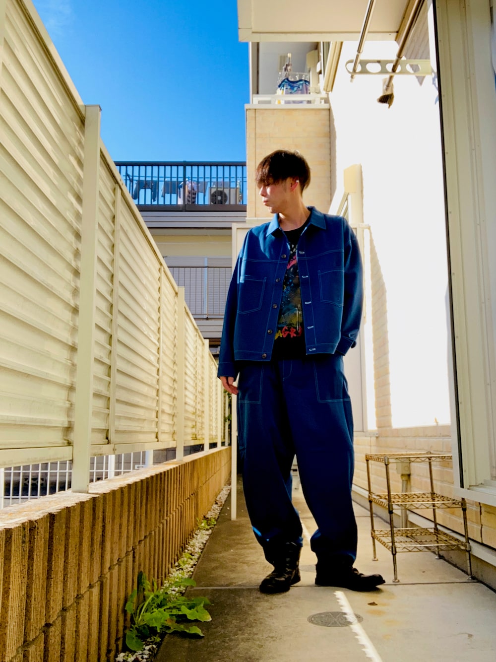 ブルー系のセットアップ、ブラック系のTシャツ/カットソー、ブラック系のブーツを着用したメンズの秋コーディネートの1枚目の写真