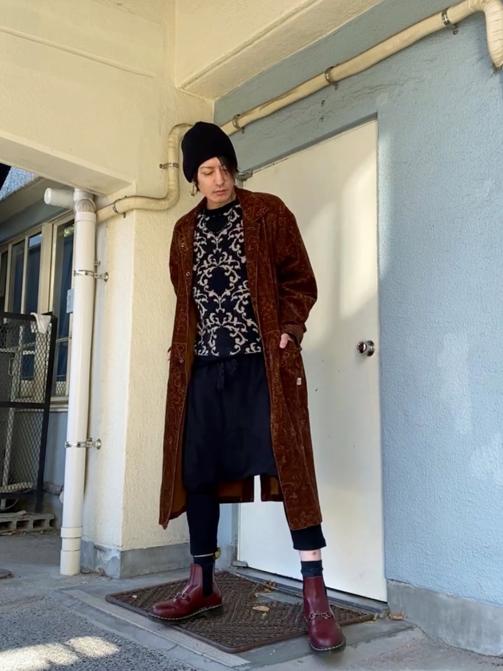 ブラック系のニット/セーター、ブラウン系のその他アウター、ブラック系のその他パンツを着用したメンズの冬コーディネートの1枚目の写真