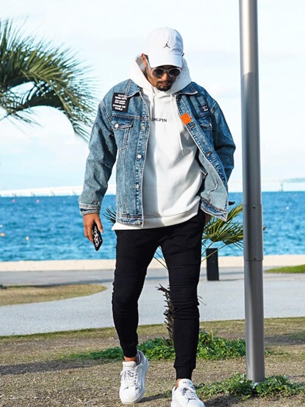 ブルー系のデニムジャケット、ホワイト系のパーカー、ブラック系のスウェットパンツを着用したメンズの冬コーディネートの1枚目の写真