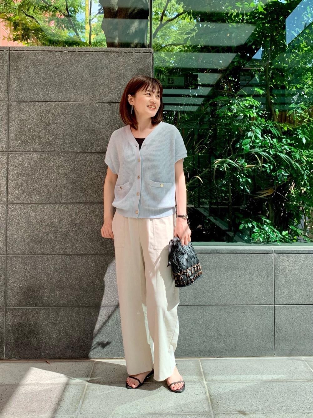 ベージュ系のその他パンツ、ブラック系のショルダーバッグ、ブルー系のベストを着用したレディースの春コーディネートの1枚目の写真