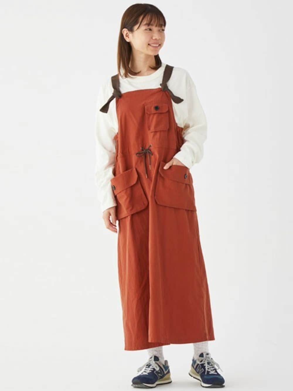 レッド系のジャンパースカート、ホワイト系のTシャツ/カットソーを着用したレディースの秋コーディネートの1枚目の写真