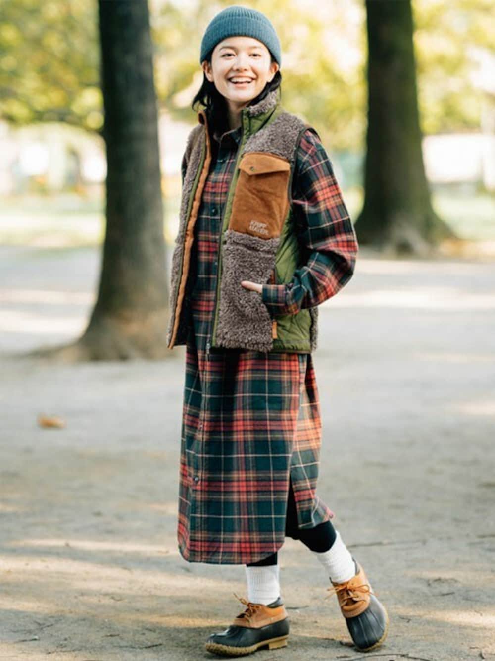 ブラウン系のベスト、レッド系のシャツワンピースを着用したレディースの秋コーディネートの1枚目の写真