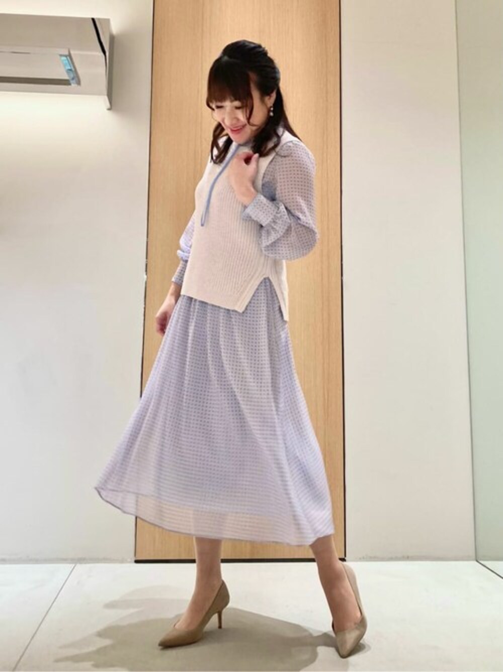 ブルー系のワンピース、パープル系のニット/セーターを着用したレディースの春コーディネートの1枚目の写真