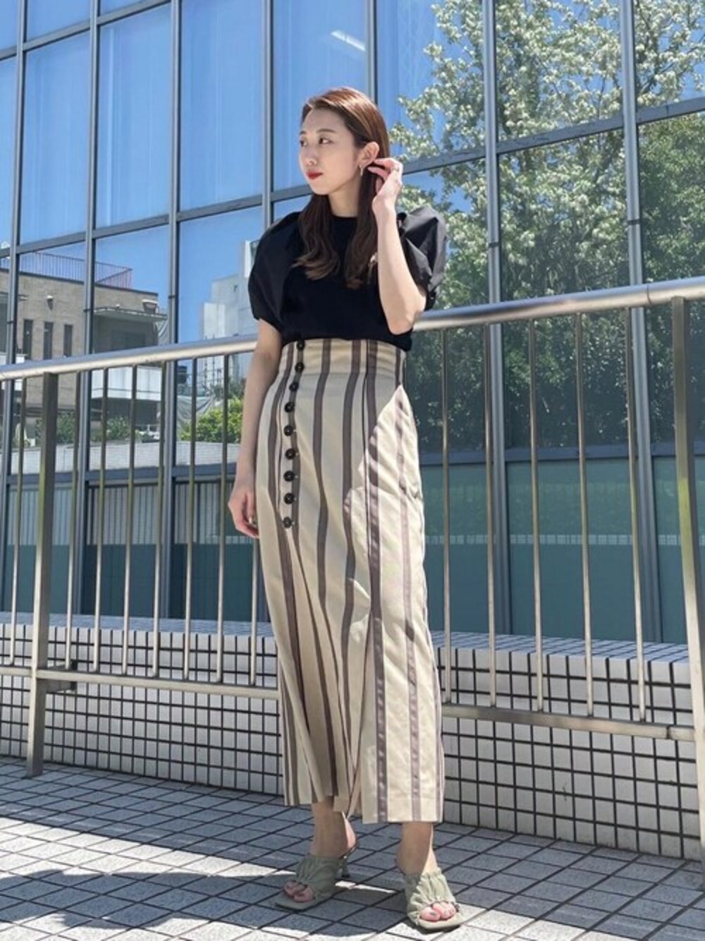 ベージュ系のスカートを着用したレディースの春コーディネートの1枚目の写真