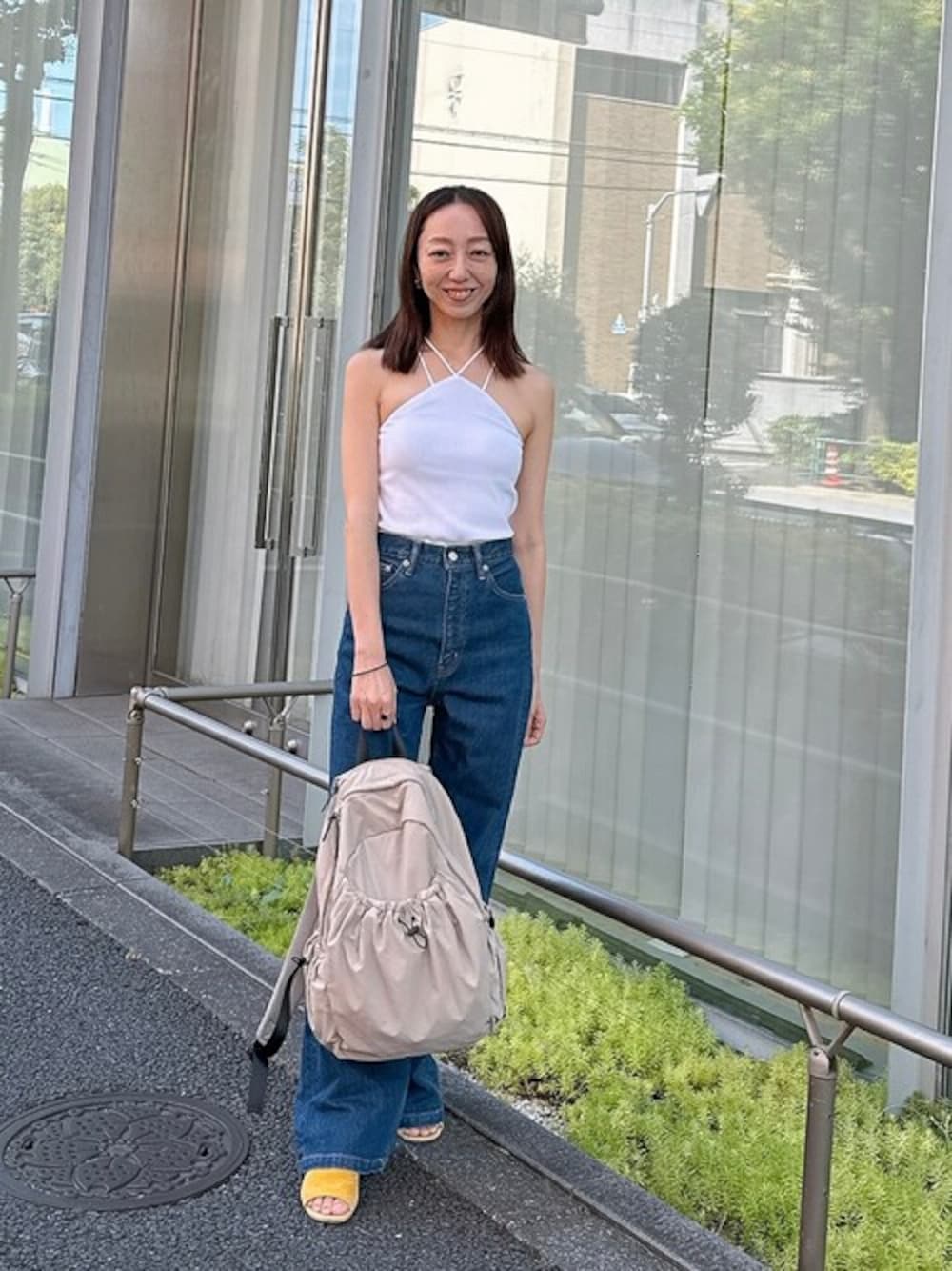 ベージュ系のバックパック/リュック、ホワイト系のキャミソールを着用したレディースの秋コーディネートの1枚目の写真