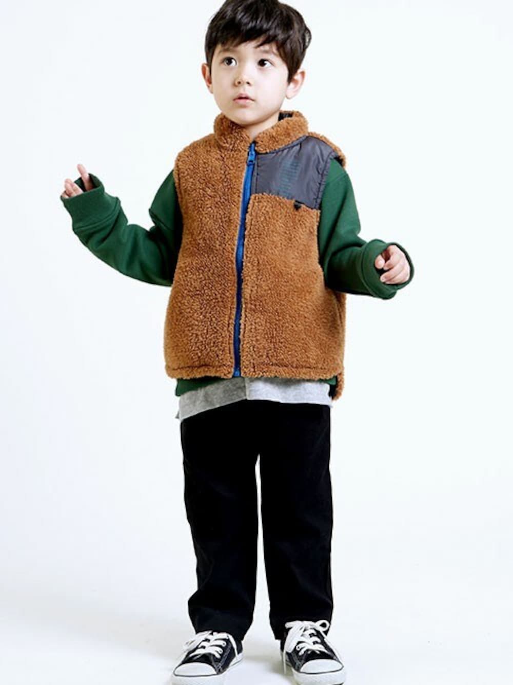 グリーン系のスウェット、ブラウン系のベスト、ブラック系のその他パンツを着用したキッズの秋コーディネートの1枚目の写真