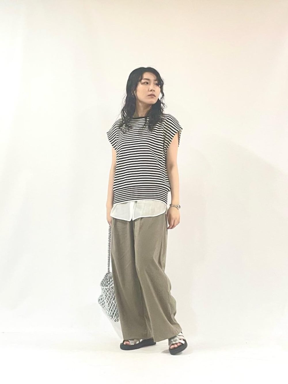 その他のタンクトップ、シルバー系のショルダーバッグ、ホワイト系のニット/セーターを着用したレディースの夏コーディネートの1枚目の写真