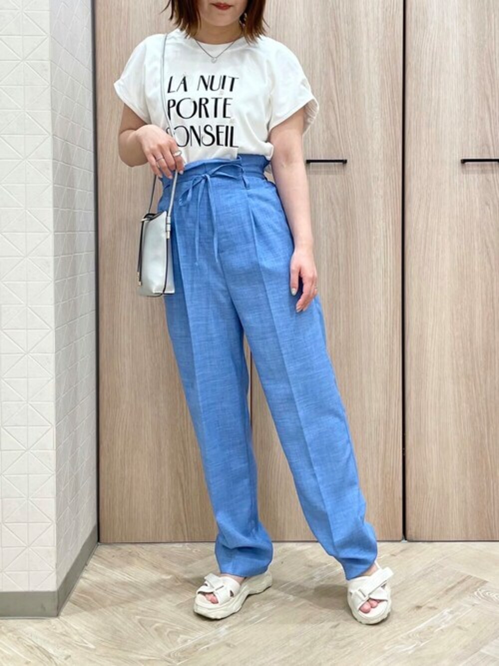 「テーパードパンツ、ロゴT、カジュアル、大人カジュアル、休日スタイル、休日コーデ、きれいめカジュアル、淡色コーデ、初夏コーデ、スマホショルダー」｜「ELVENCE DEUXのパールフロッキーロゴＴ（Tシャツ/カットソー、ホワイト系）」を使った、ELVENCE DEUXさん（レディース・150cm）の春コーディネートの1枚目の写真