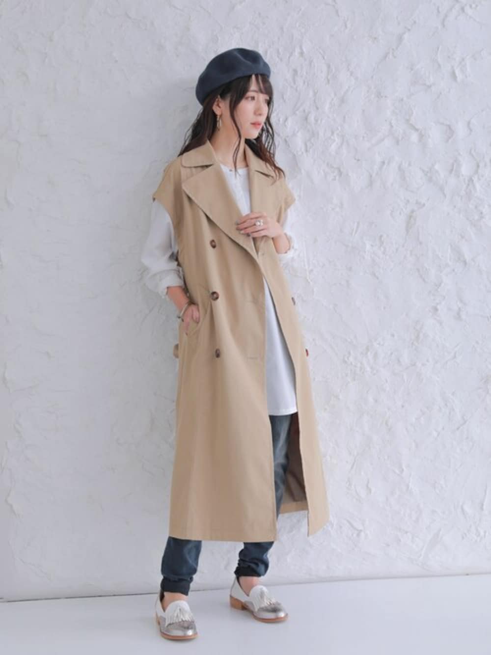 ベージュ系のトレンチコートを着用したレディースの冬コーディネートの1枚目の写真