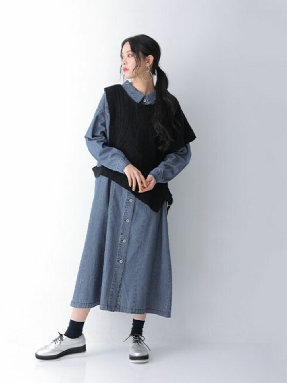 ブルー系のシャツワンピース、ブラック系のベストを着用したレディースの春コーディネートの1枚目の写真
