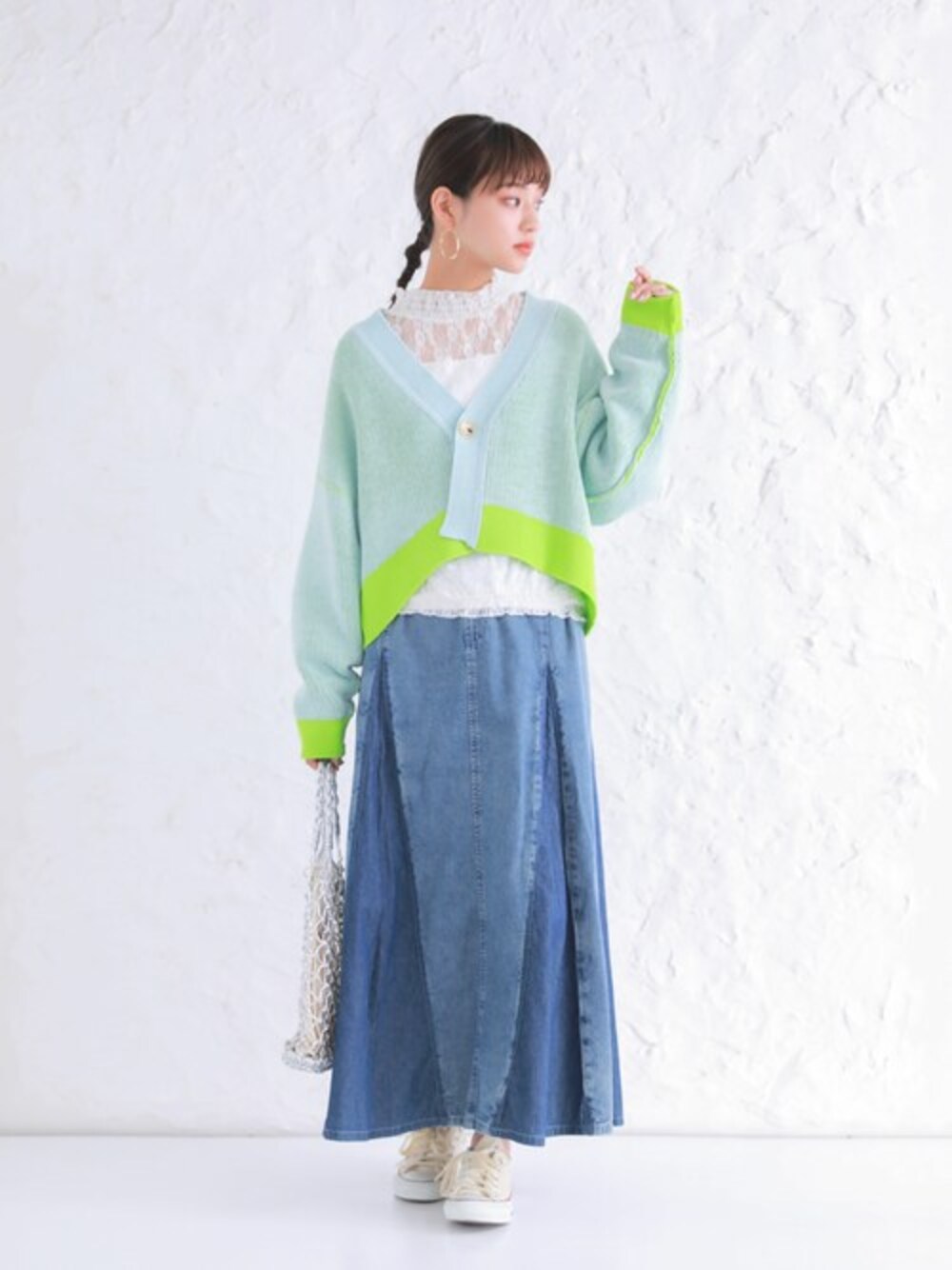 グリーン系のカーディガン/ボレロ、ブルー系のデニムスカートを着用したレディースの春コーディネートの1枚目の写真