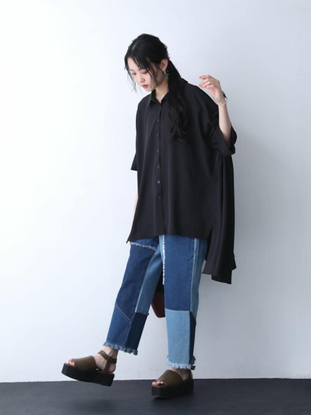 ブラック系のシャツ/ブラウス、ブルー系のデニムパンツを着用したレディースの春コーディネートの1枚目の写真