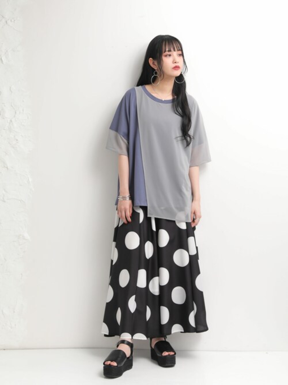 ブルー系のTシャツ/カットソー、ブラック系のスカートを着用したレディースの春コーディネートの1枚目の写真