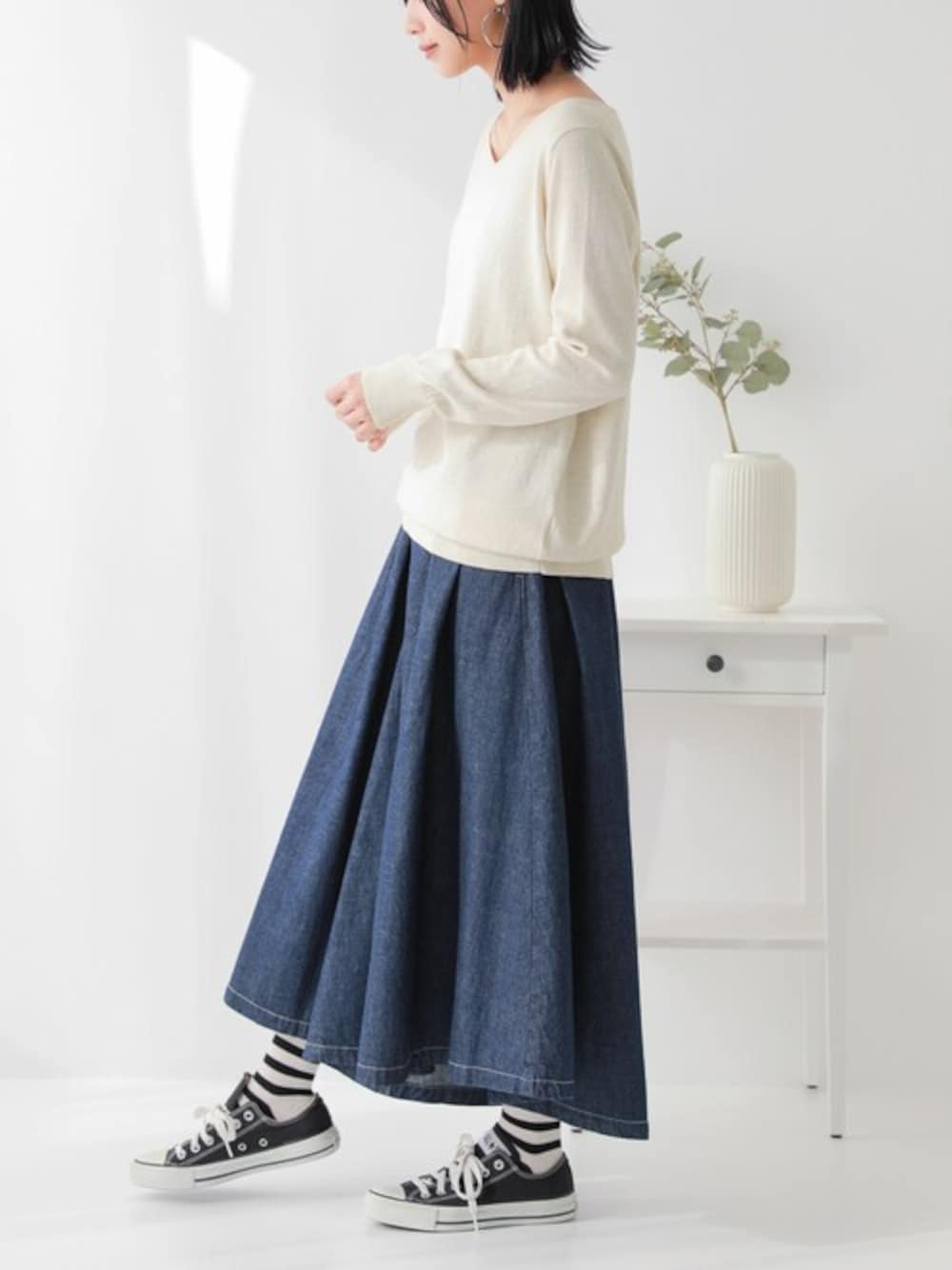 ブルー系のデニムパンツ、ベージュ系のニット/セーターを着用したレディースの冬コーディネートの1枚目の写真