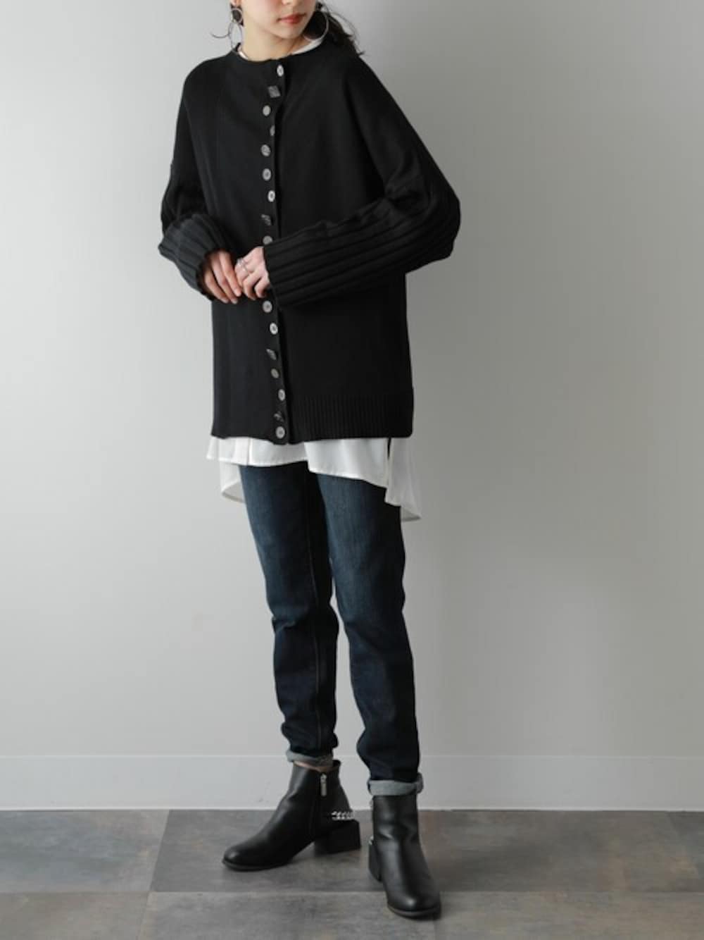 ブラック系のカーディガン/ボレロ、ブルー系のデニムパンツ、ホワイト系のシャツ/ブラウスを着用したレディースの冬コーディネートの1枚目の写真