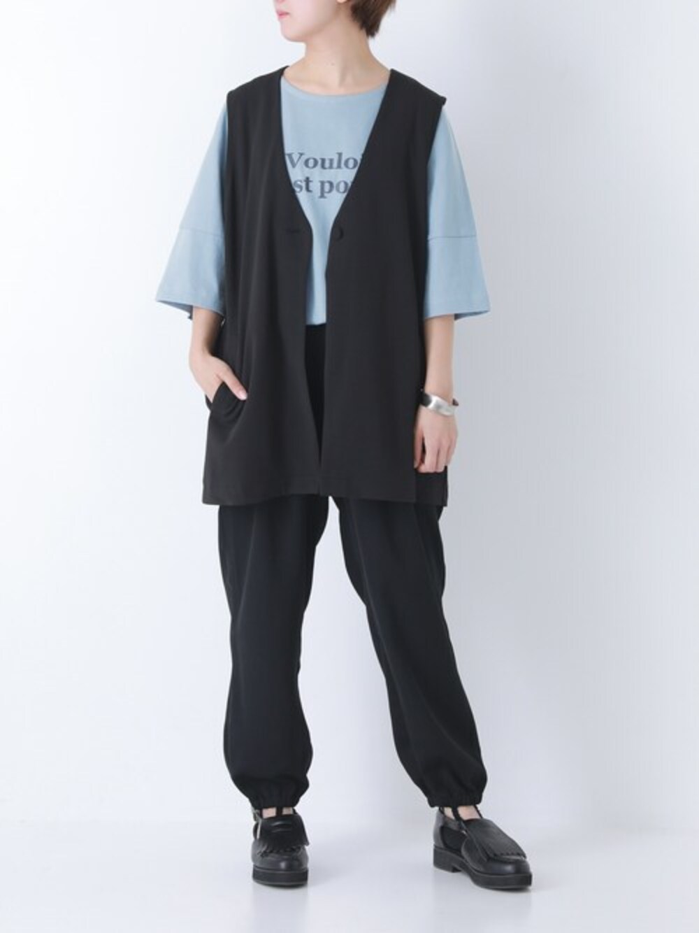 ブラック系のベスト、ブラック系のその他パンツ、ブルー系のTシャツ/カットソーを着用したレディースの春コーディネートの1枚目の写真