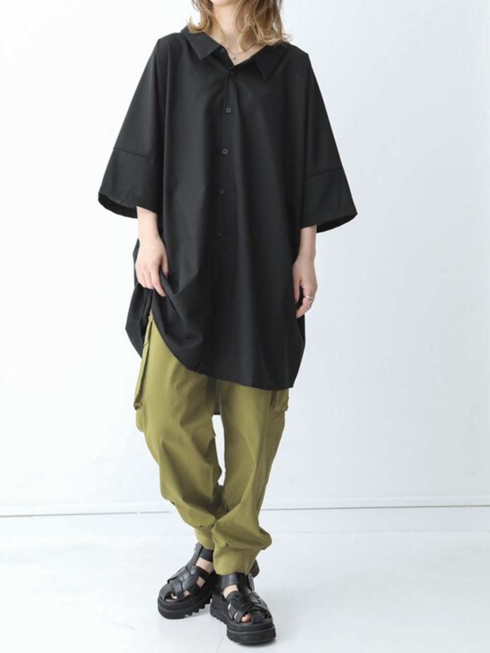 ブラック系のシャツ/ブラウス、グリーン系のカーゴパンツを着用したレディースの春コーディネートの1枚目の写真