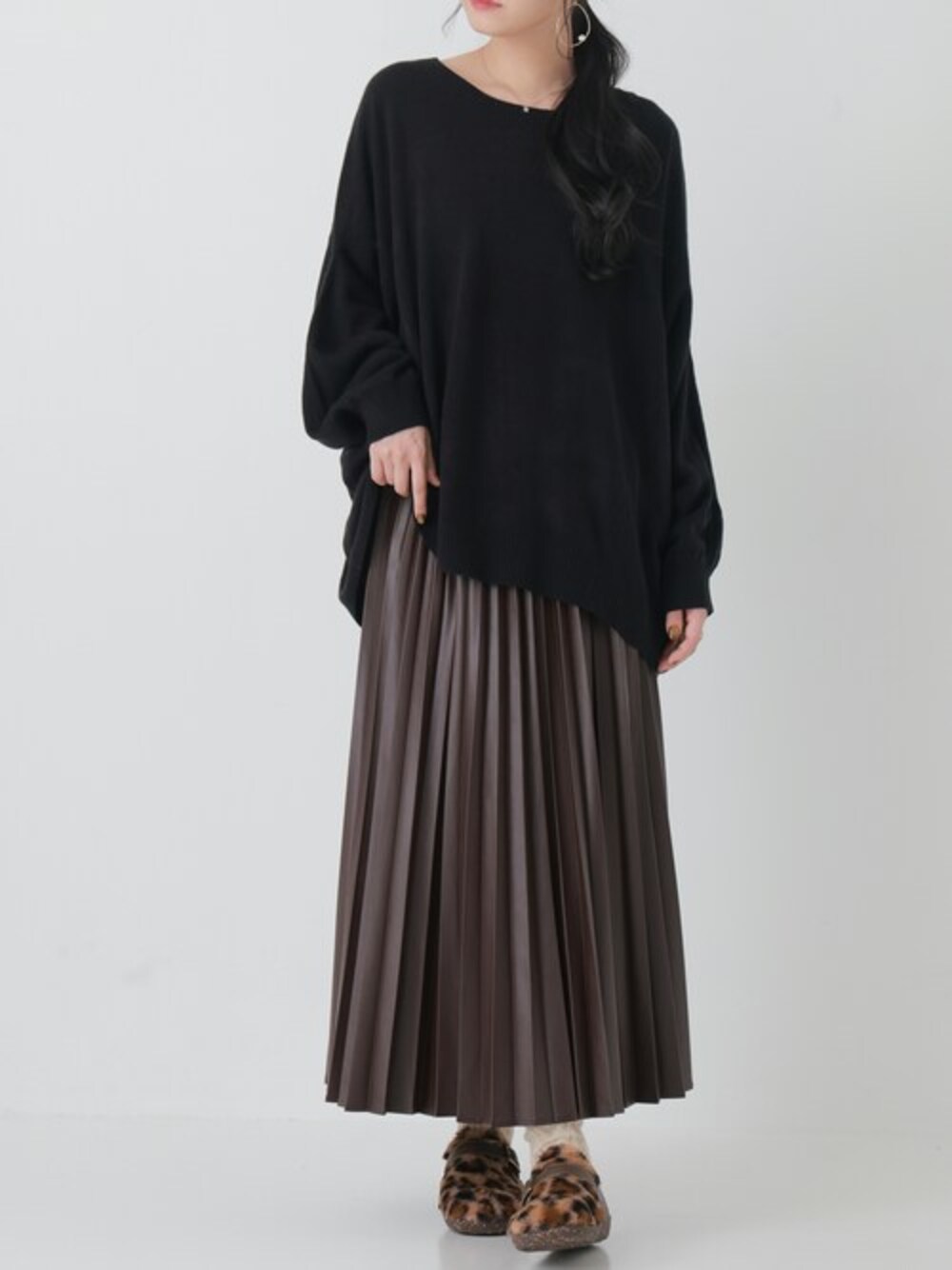 ブラウン系のスカートを着用したレディースの秋コーディネートの1枚目の写真